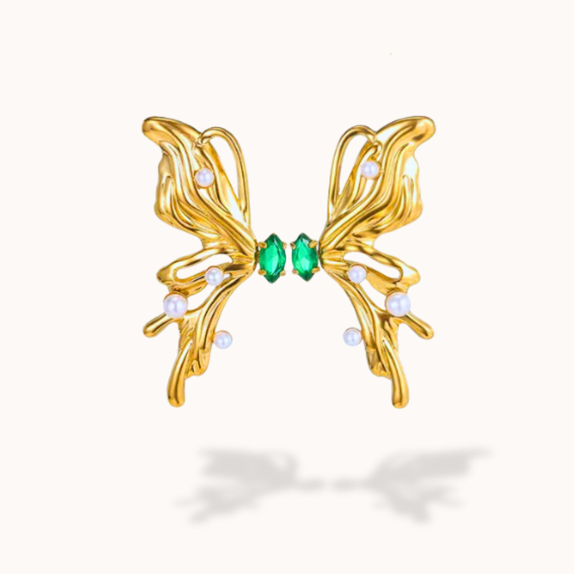 Gold butterfly-shaped earring with green gemstones on a white background