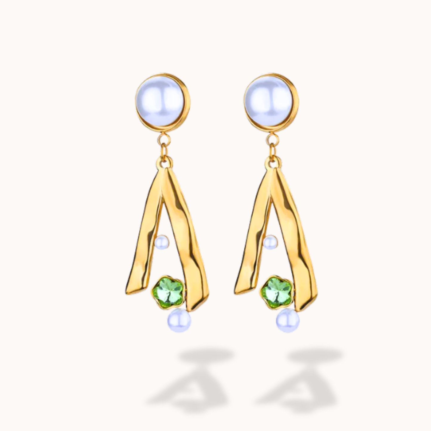 Gold earrings with green gemstones on a white background