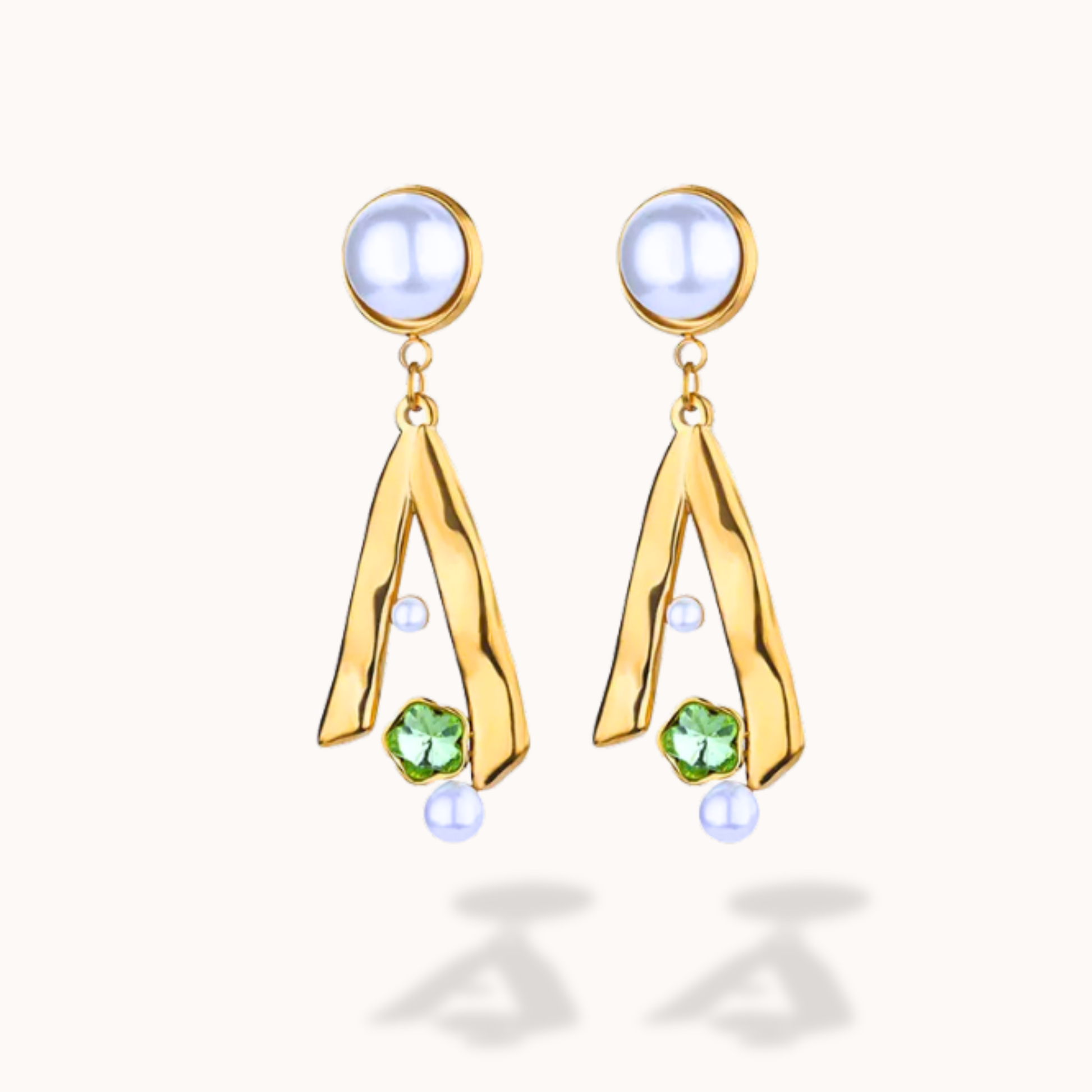 Gold earrings with green gemstones on a white background