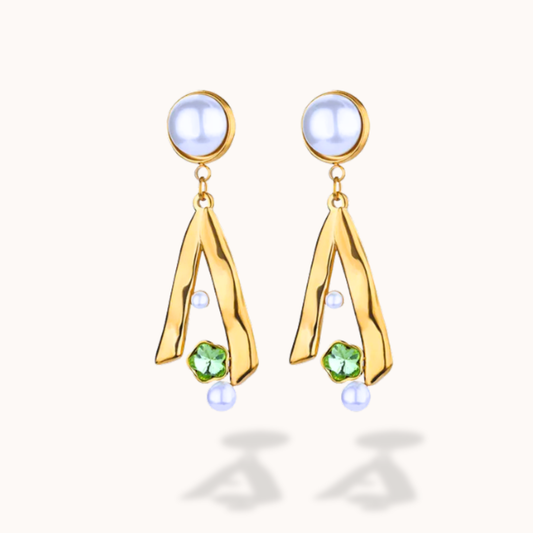 Gold earrings with green gemstones on a white background