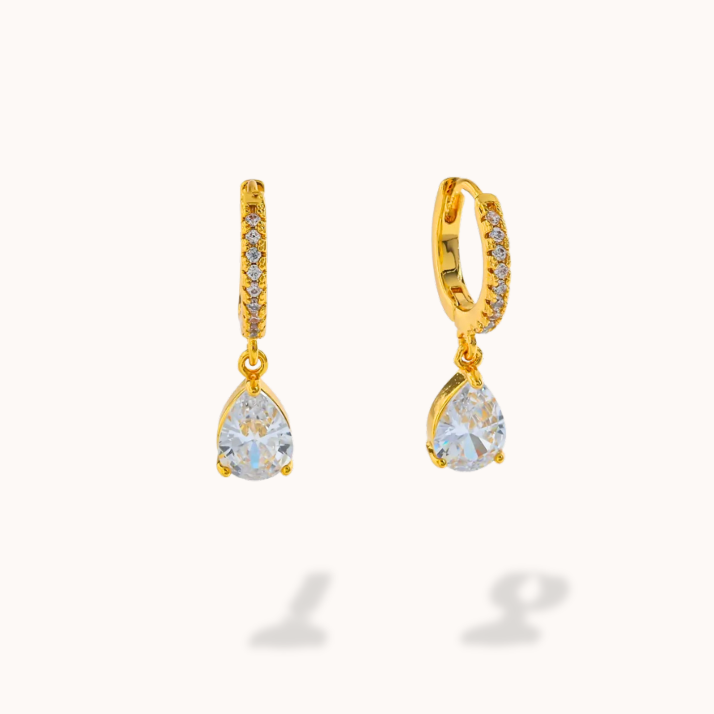 Gold earrings with teardrop-shaped gemstones on a white background