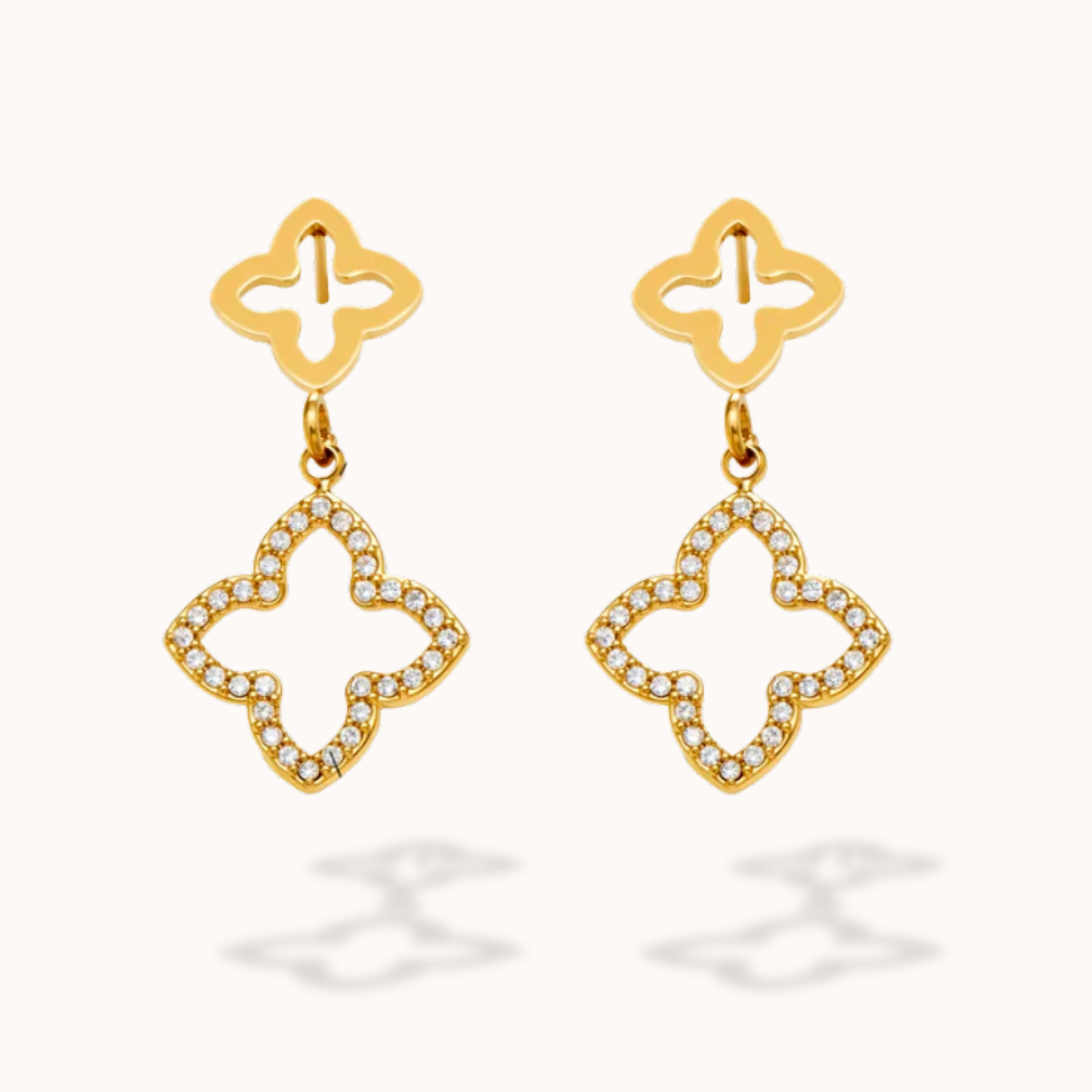 Gold earrings with diamond-like stones on a white background