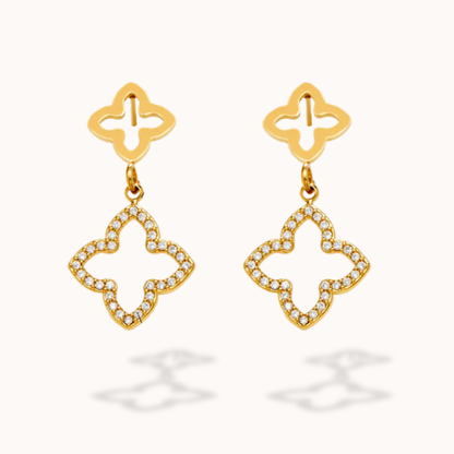 Gold earrings with diamond-like stones on a white background