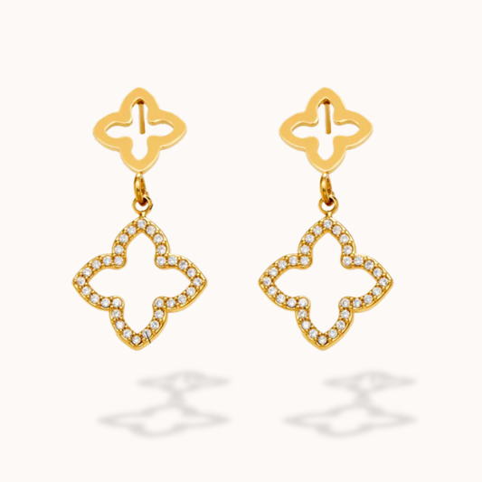 Gold earrings with diamond-like stones on a white background