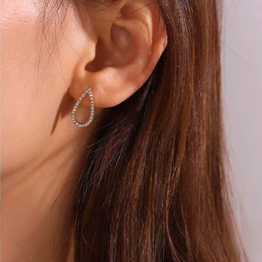 Close-up of an ear wearing a golld hoop earring with a blurred background 