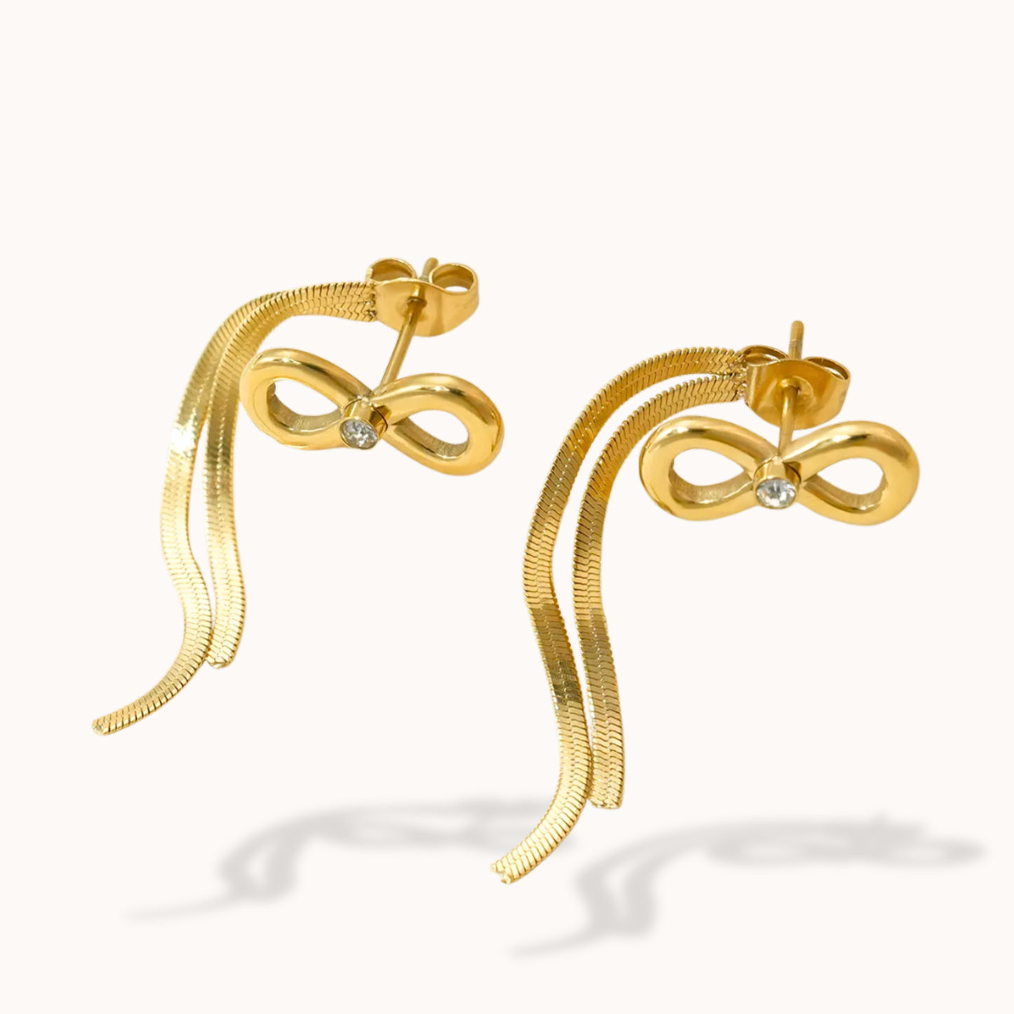 Gold bow-shaped earrings on a white background