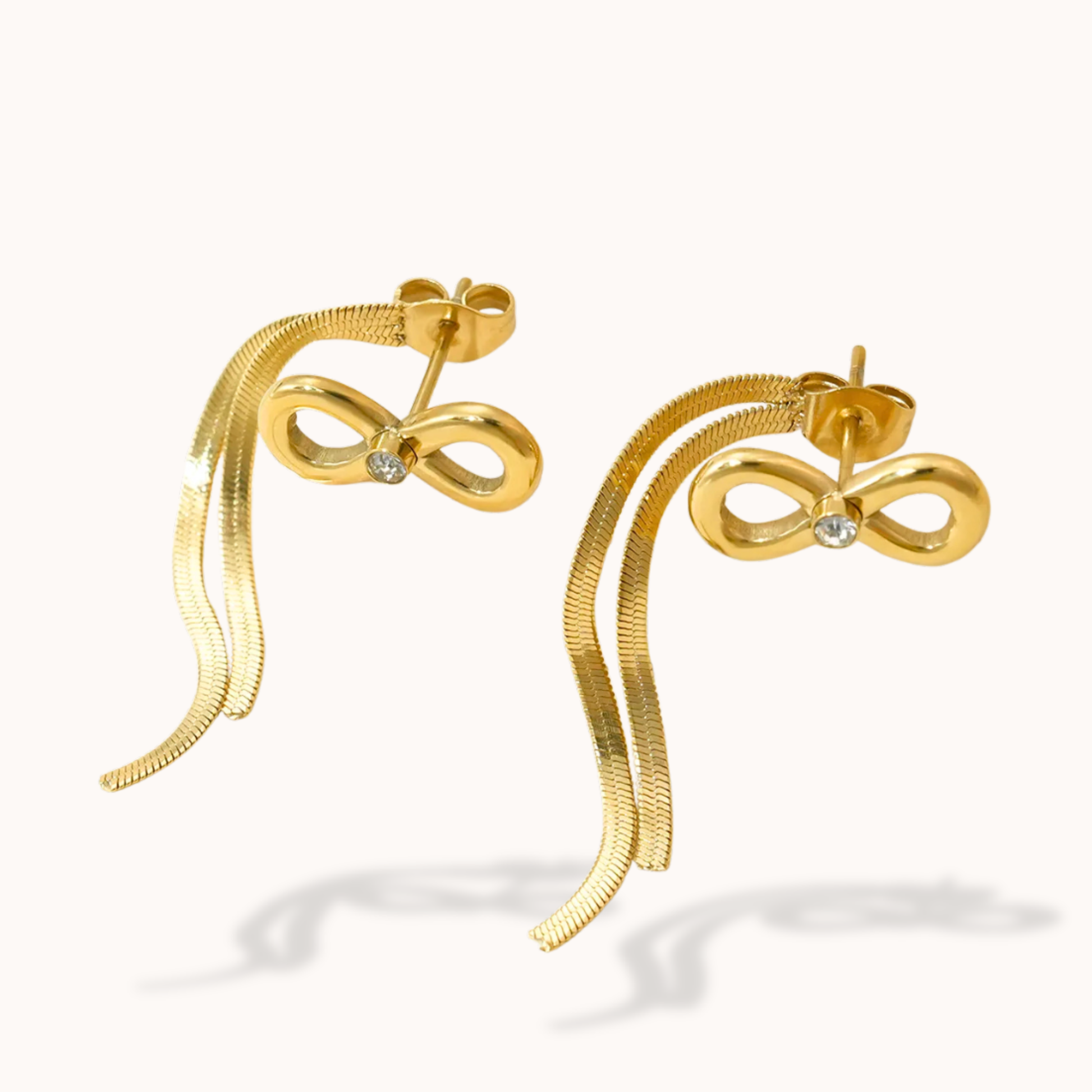 Gold bow-shaped earrings on a white background