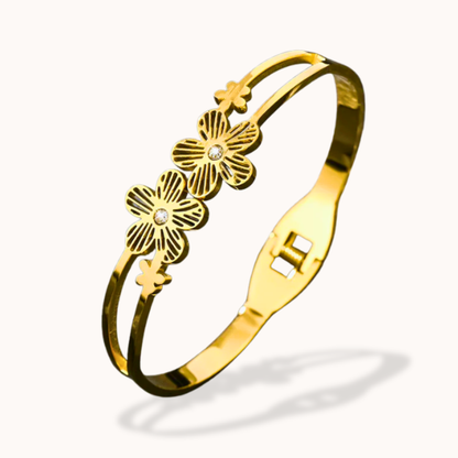 Gold bracelet with floral designs on a white background