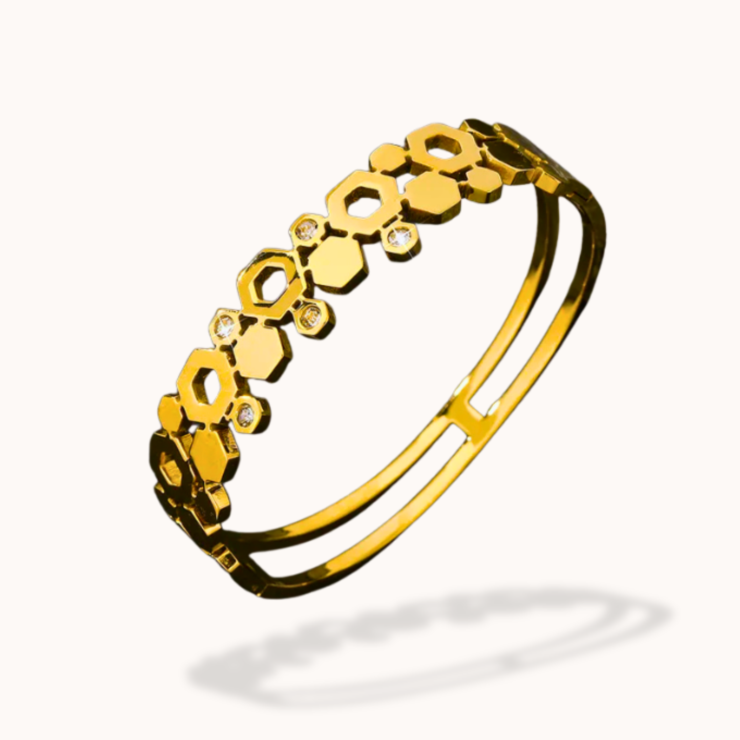 Gold bracelet with hexagonal patterns on a white background