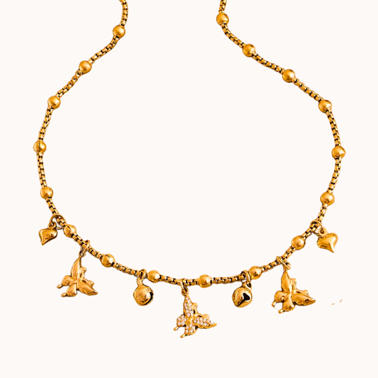 Gold necklace with charms on a white background