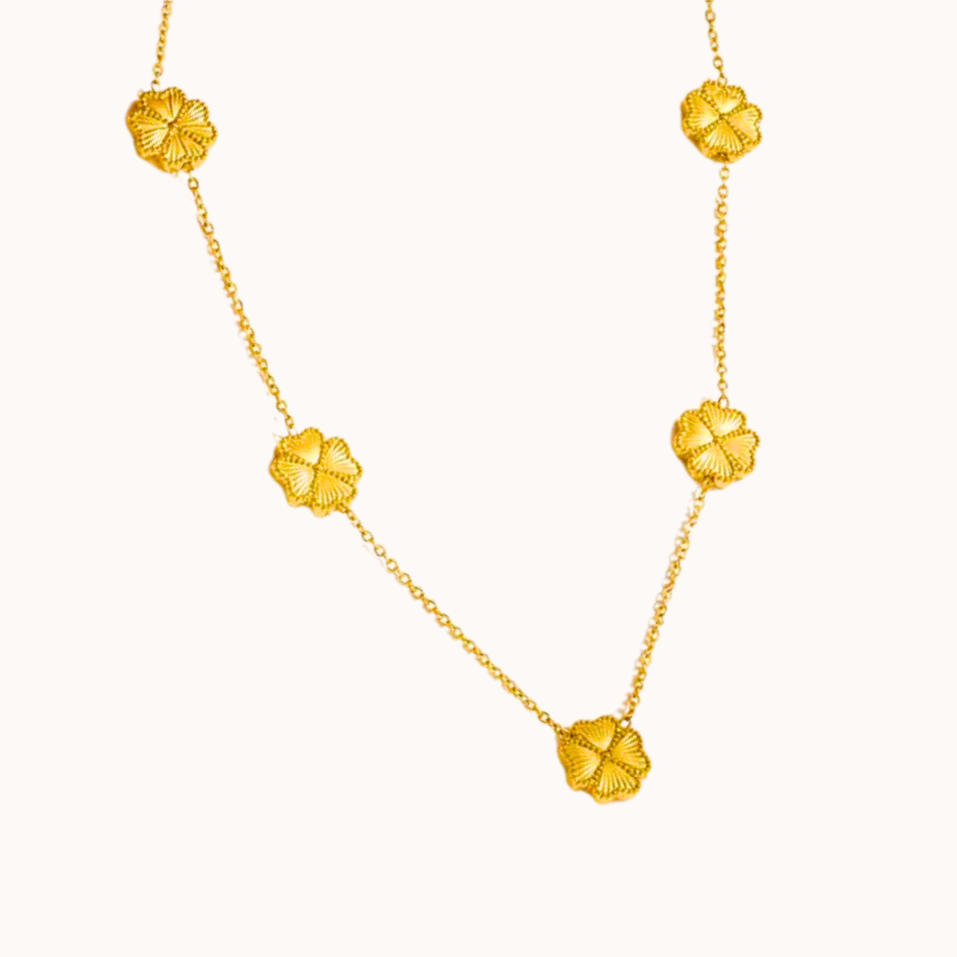 Gold necklace with floral pendants on a white background