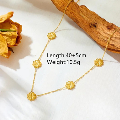 Gold necklace with floral pendants on a white background