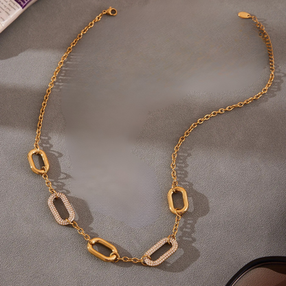Gold chain necklace on a gray surface