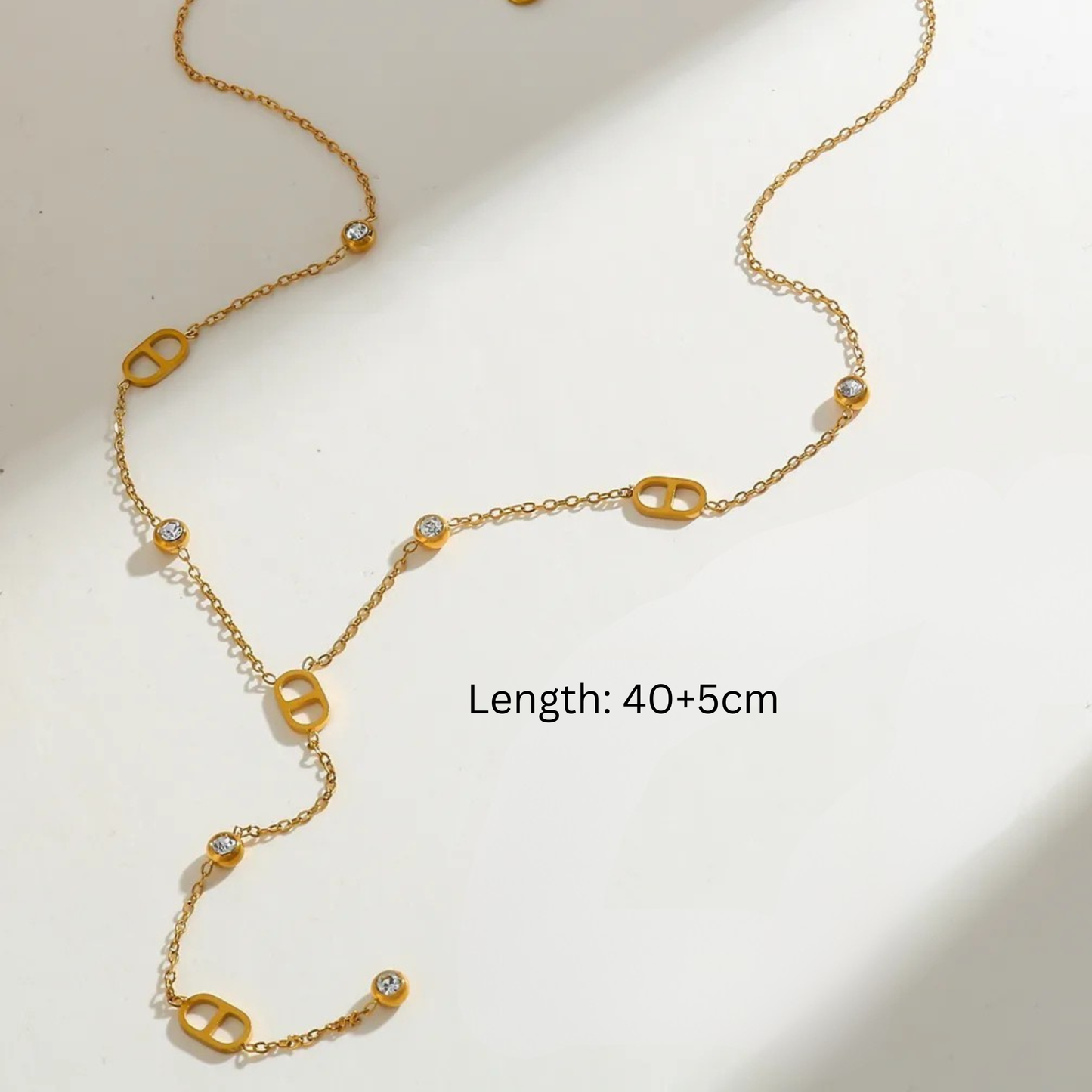 Gold chain necklace with decorative links on a light background