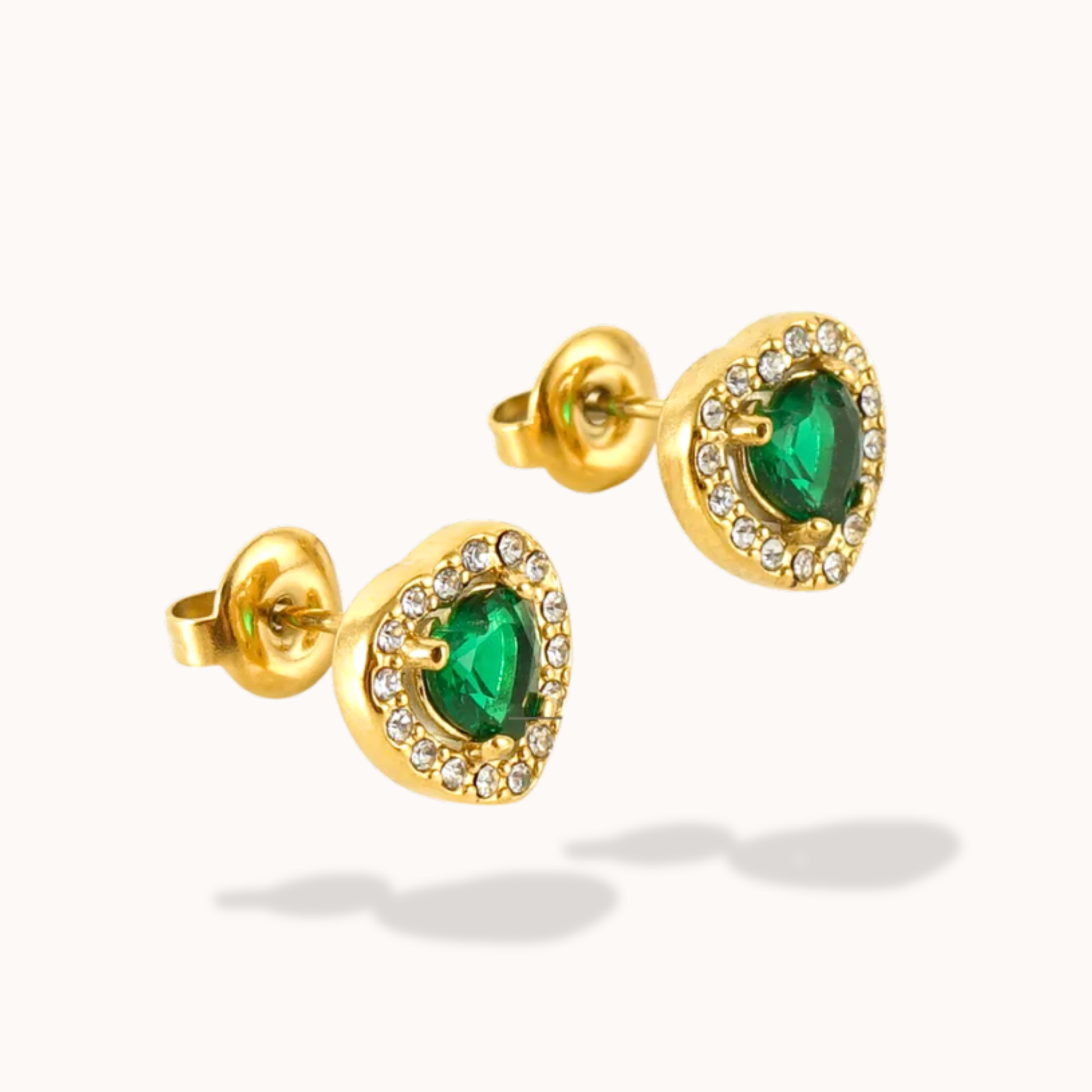 Gold earrings with green gemstones on a white background