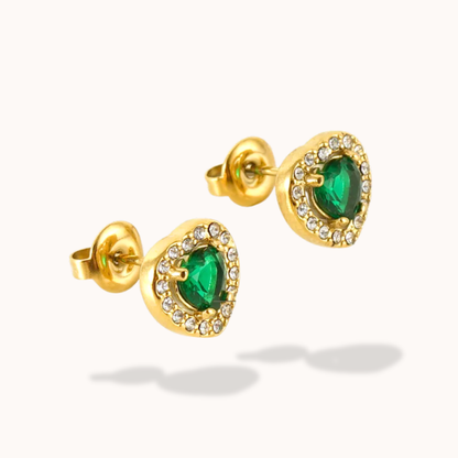 Gold earrings with green gemstones on a white background