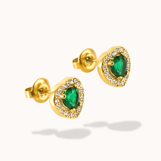 Gold earrings with green gemstones on a white background