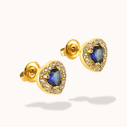 Gold earrings with blue gemstones on a white background