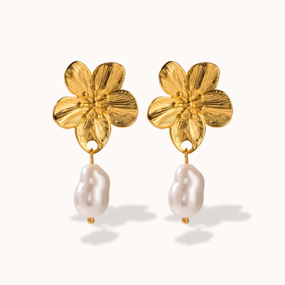 Gold flower-shaped earrings with pearl drops on a white background