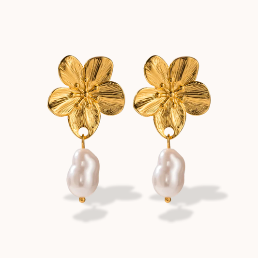 Gold flower-shaped earrings with pearl drops on a white background