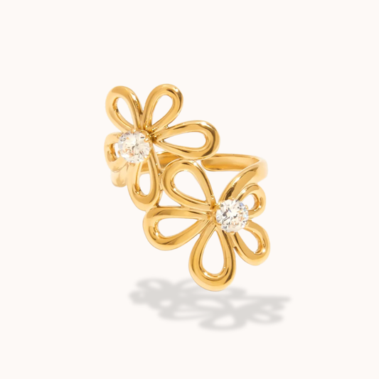 Gold flower-shaped earrings with clear gemstones on a white background