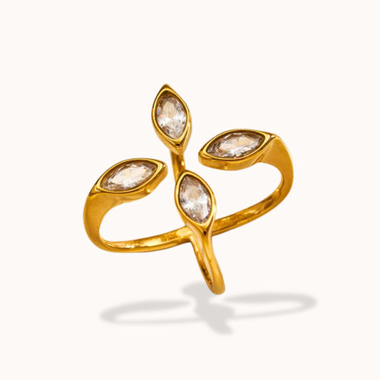 Gold ring with four diamond-like stones on a white background