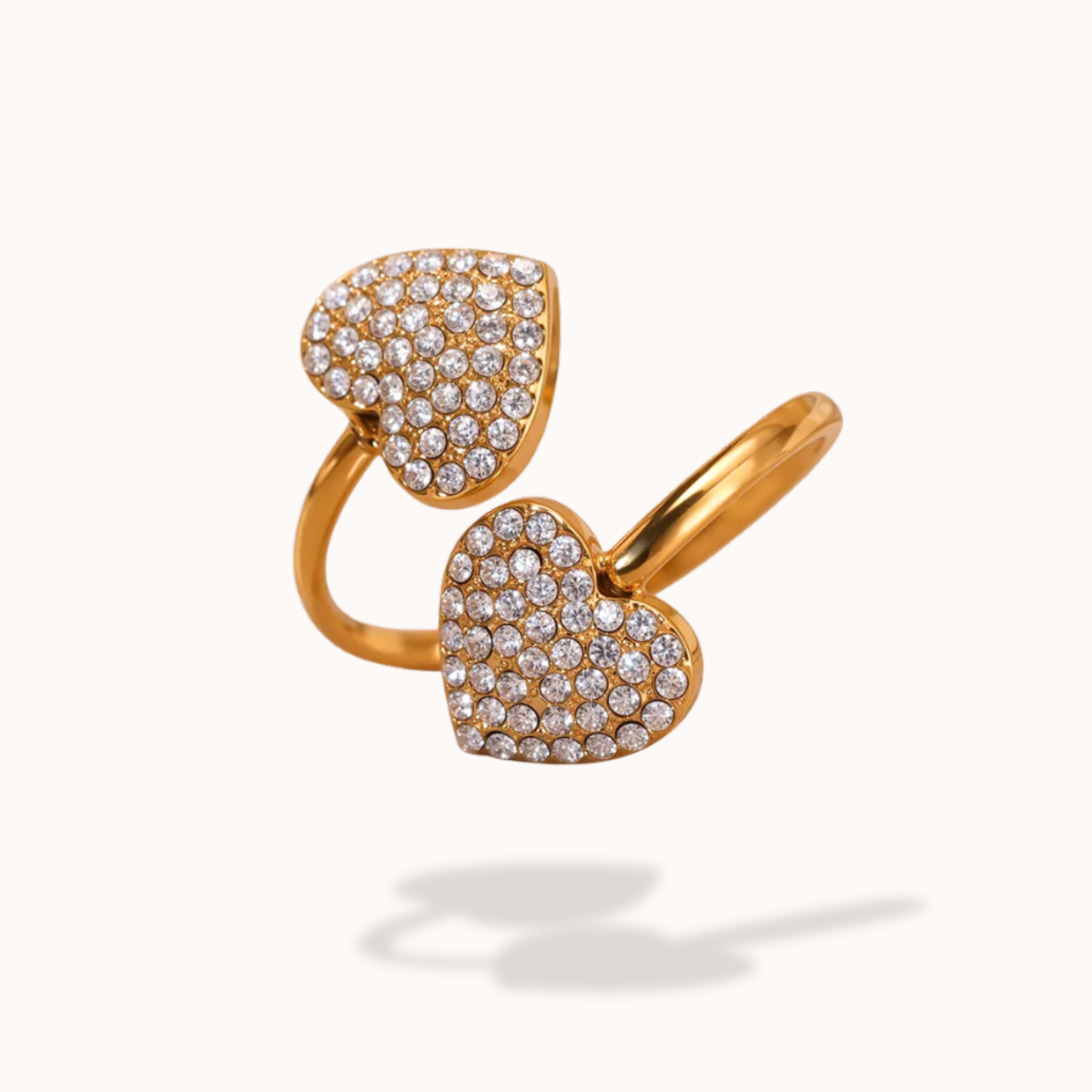 Gold heart-shaped ring with diamond accents on a white background