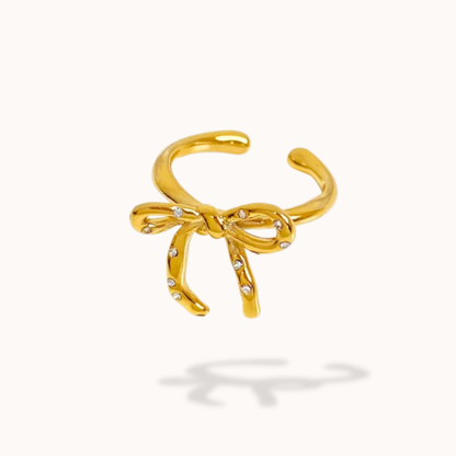 Gold bow-shaped ring on a white background