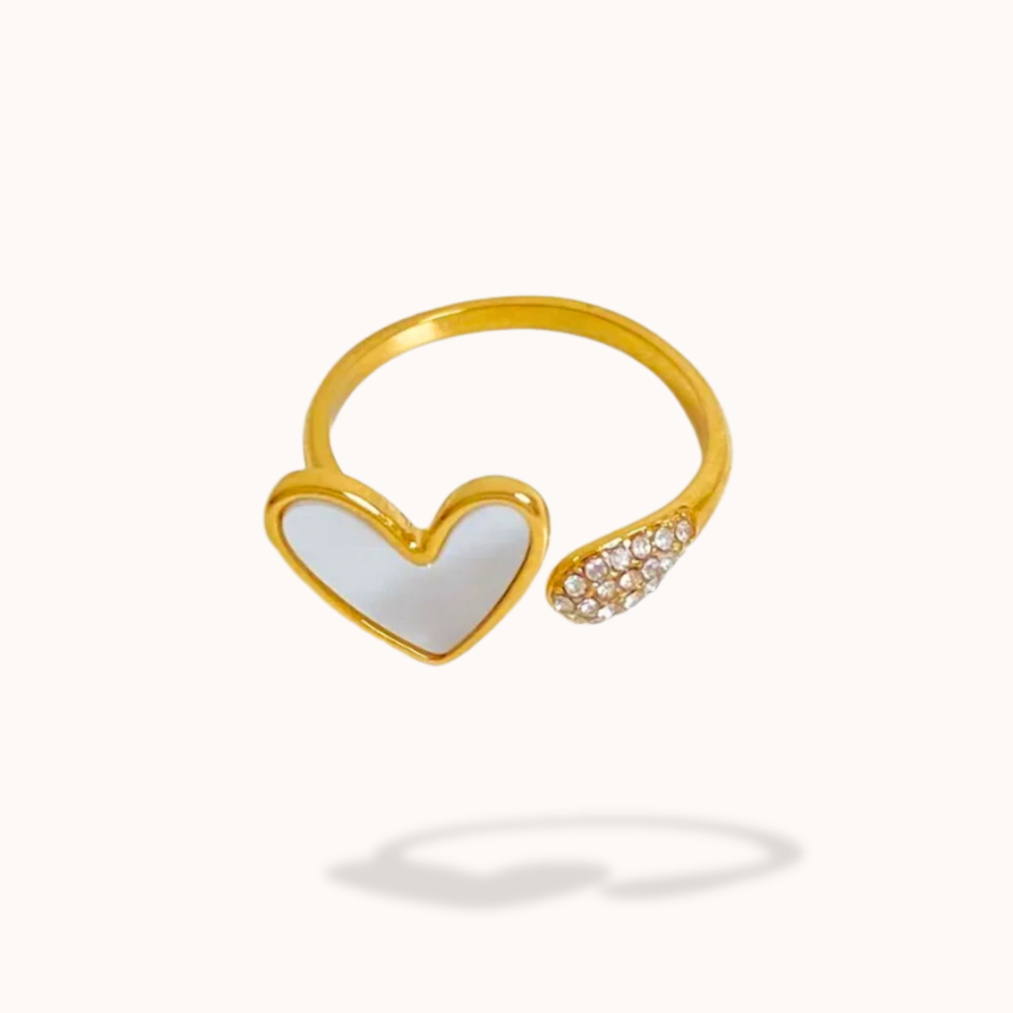 Gold ring with a heart-shaped design on a white background