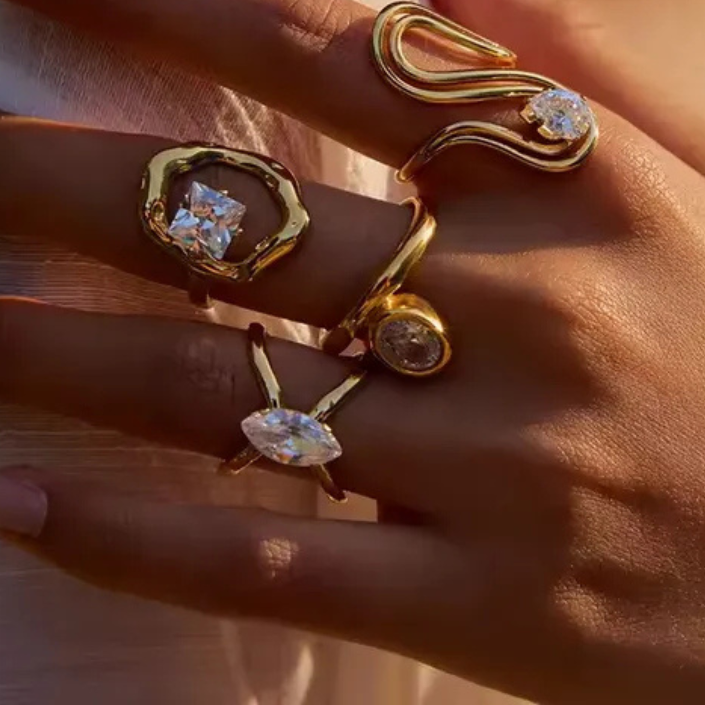 Gold rings with gemstones on a hand