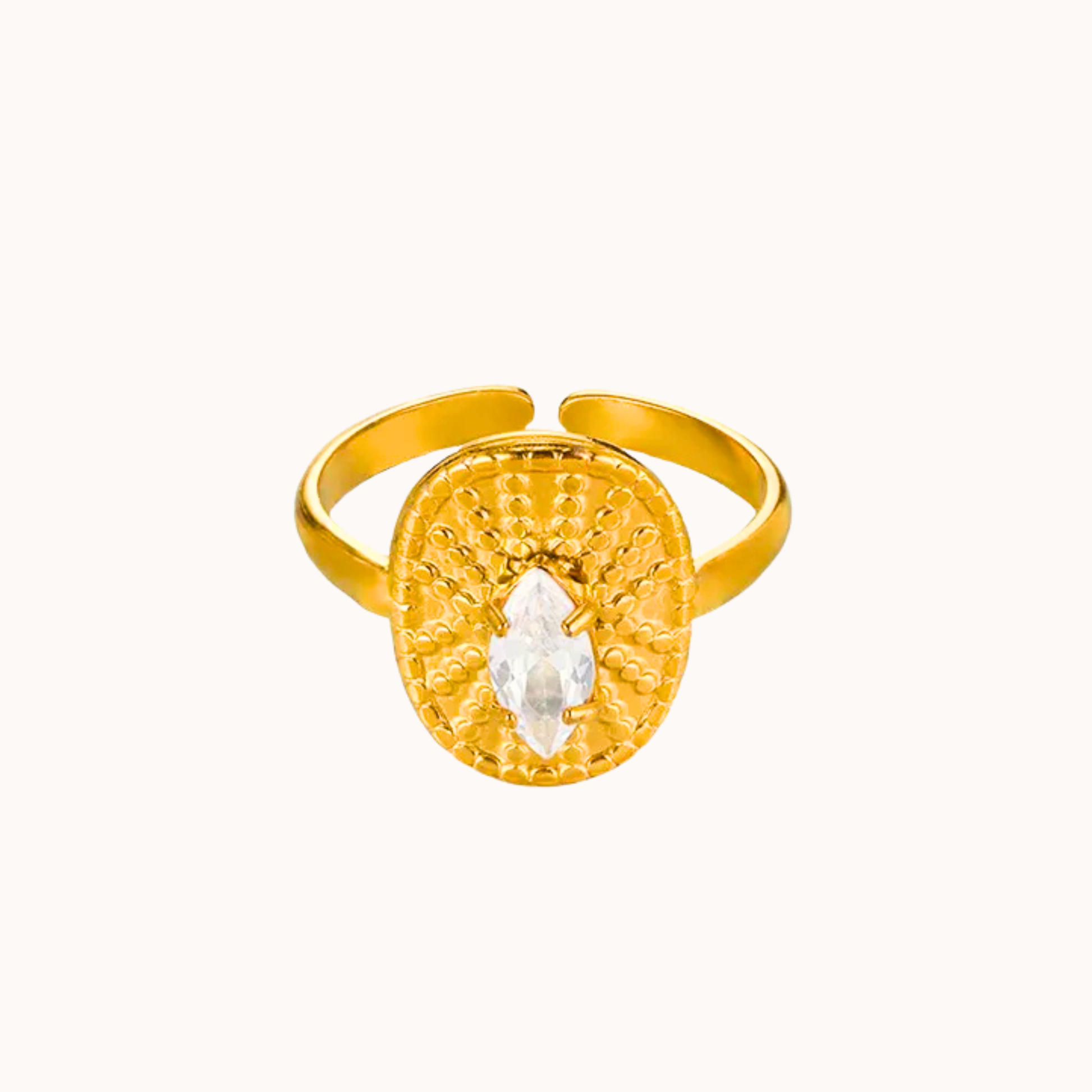 Gold ring with a circular design and central gemstone on a white background