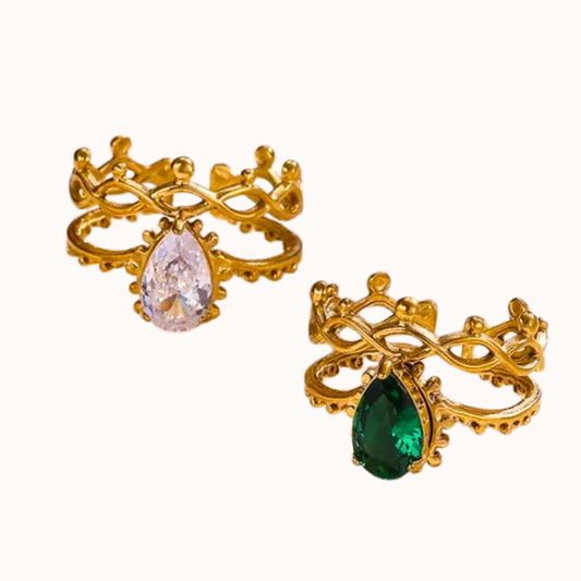Two gold-rimmed ring with gemstones on a white background