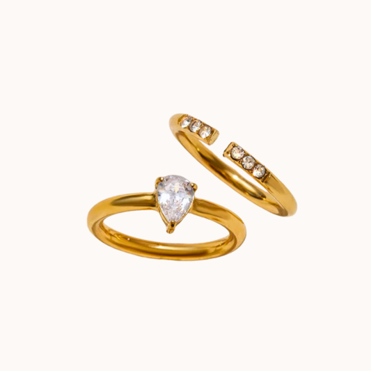Two gold rings with gemstones on a white background