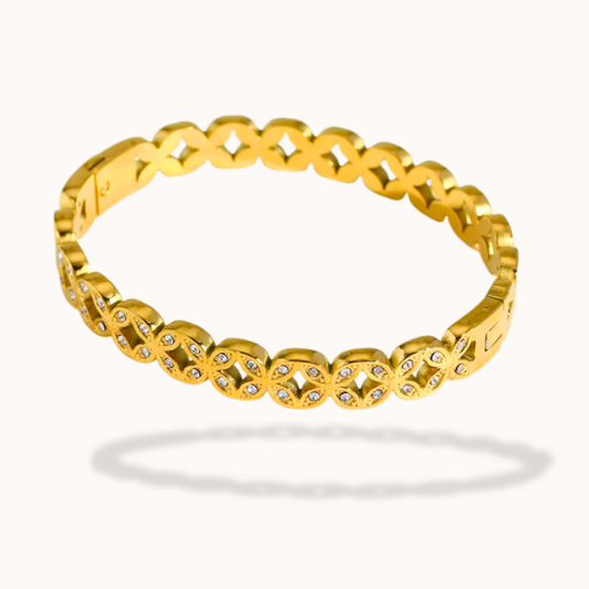 Gold bracelet with small diamonds on a white background