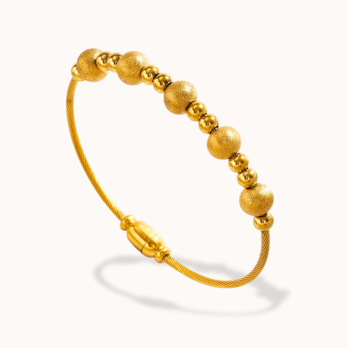 Gold beaded bracelet on a white background