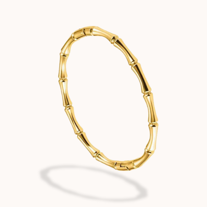 Gold bracelet with a bamboo design on a white background