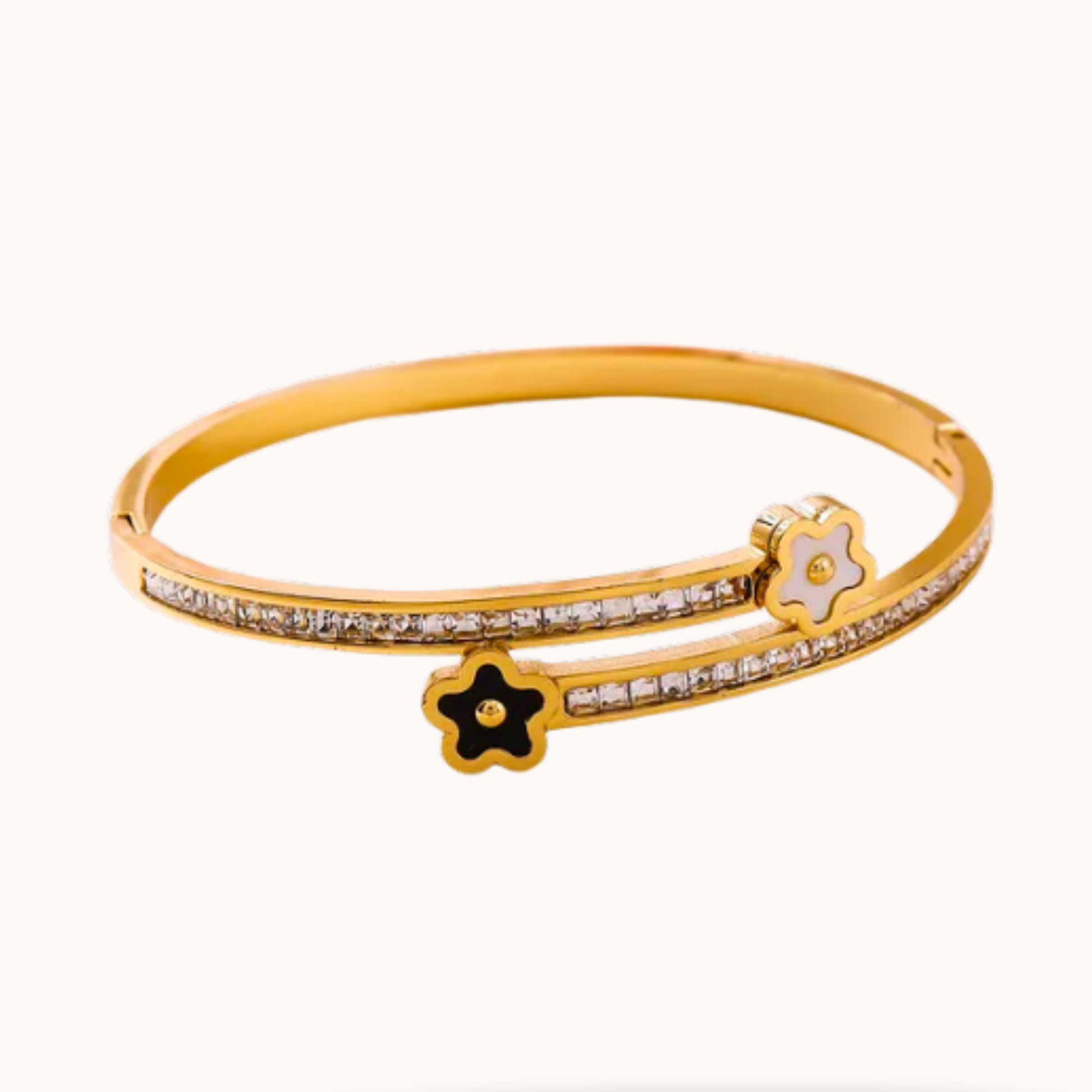 Gold bracelet with star and flower designs on a white background