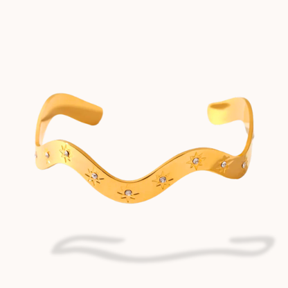 Yellow wavy necklace with small round embellishments on a white background