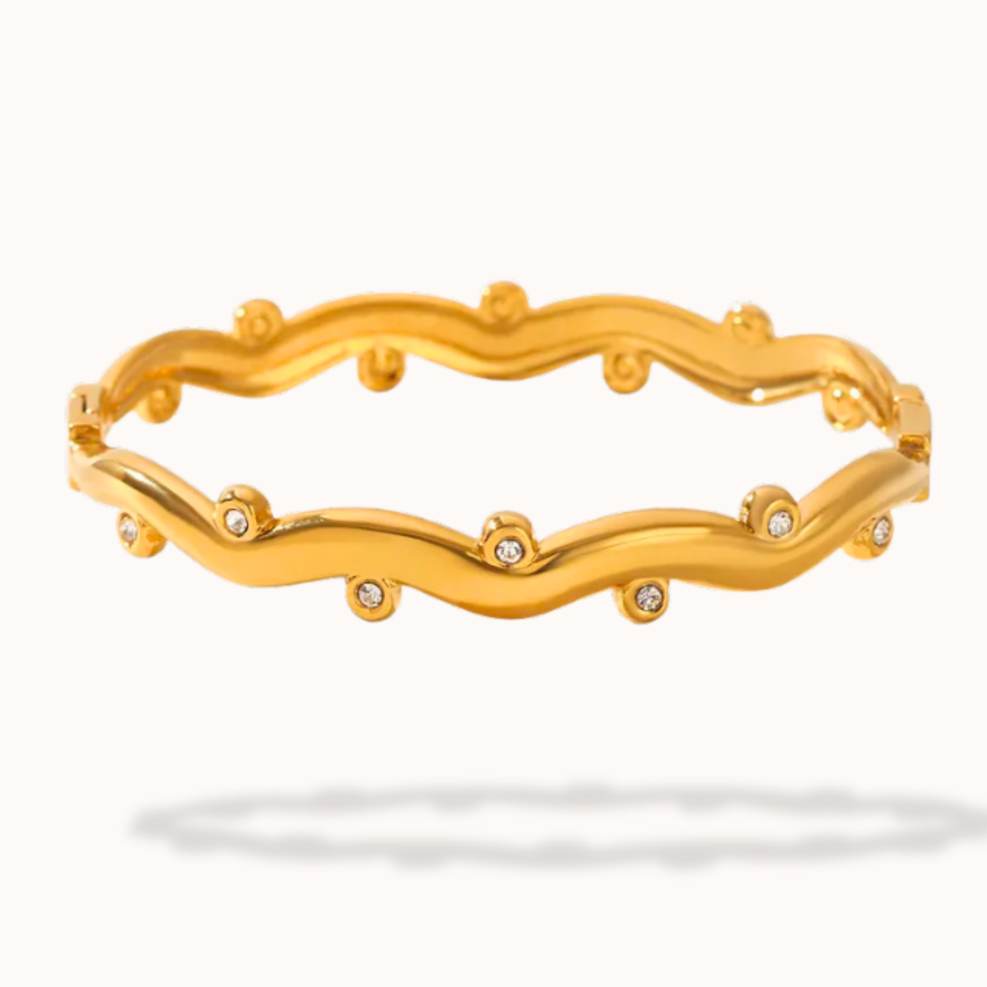 Gold bracelet with wavy design and small diamonds on a white background