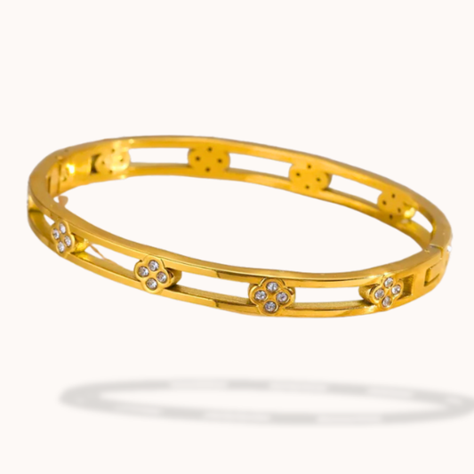 Gold bracelet with diamond accents on a white background