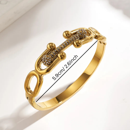 Gold bracelet with intricate design on a light background