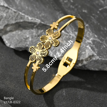 Gold bangle with floral designs on a dark stone background