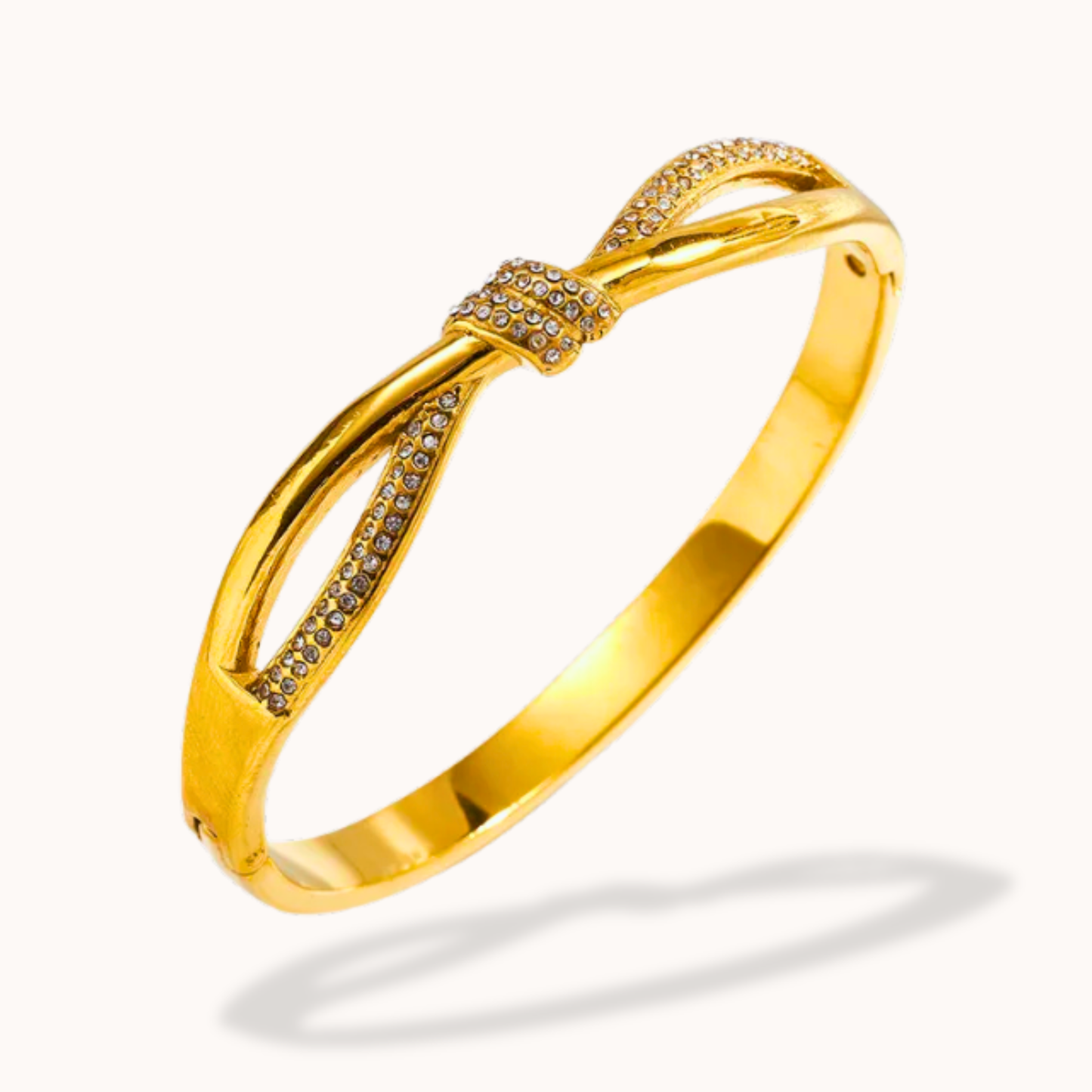 Gold bracelet with bow design on a white background