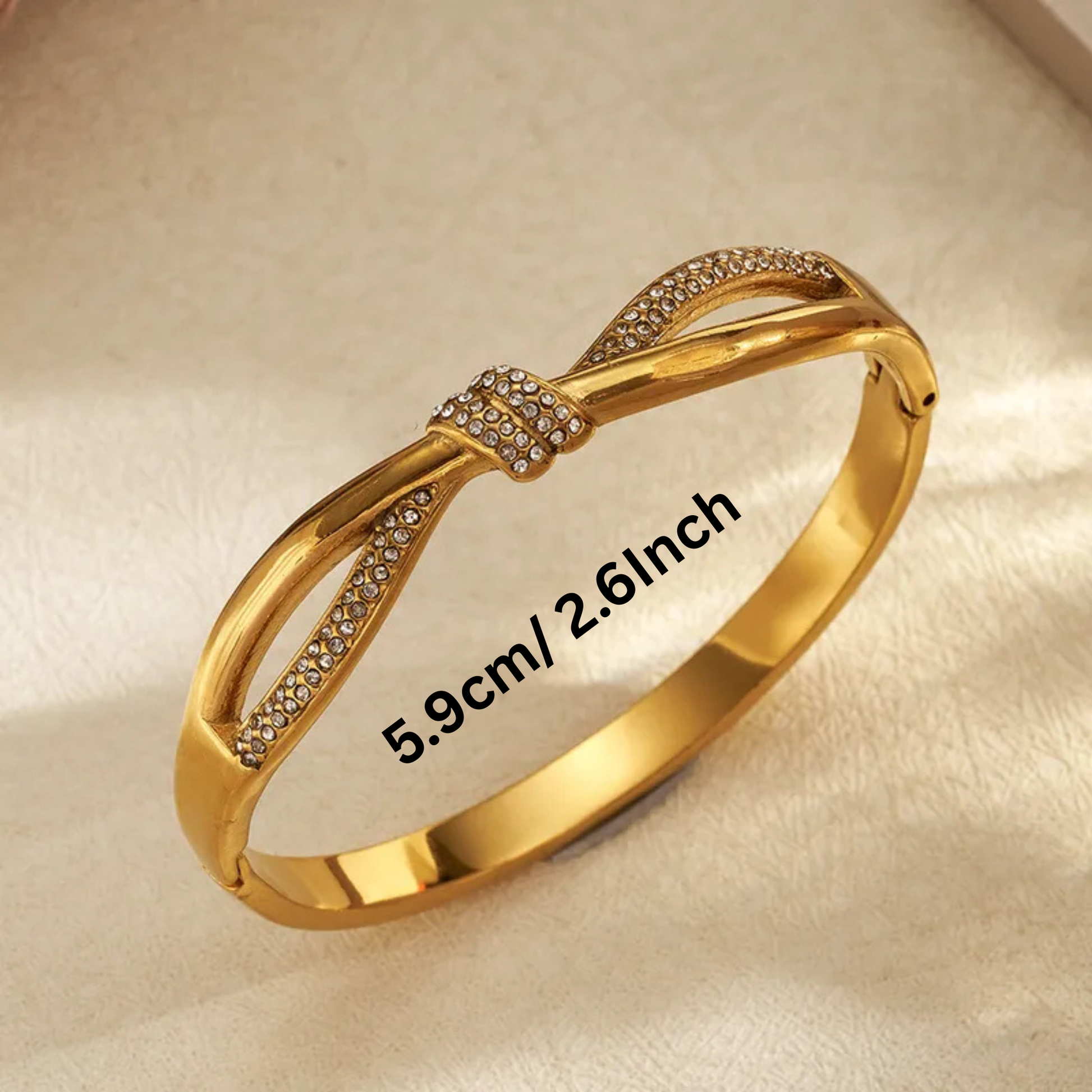Gold bracelet with diamond accents on a beige background
