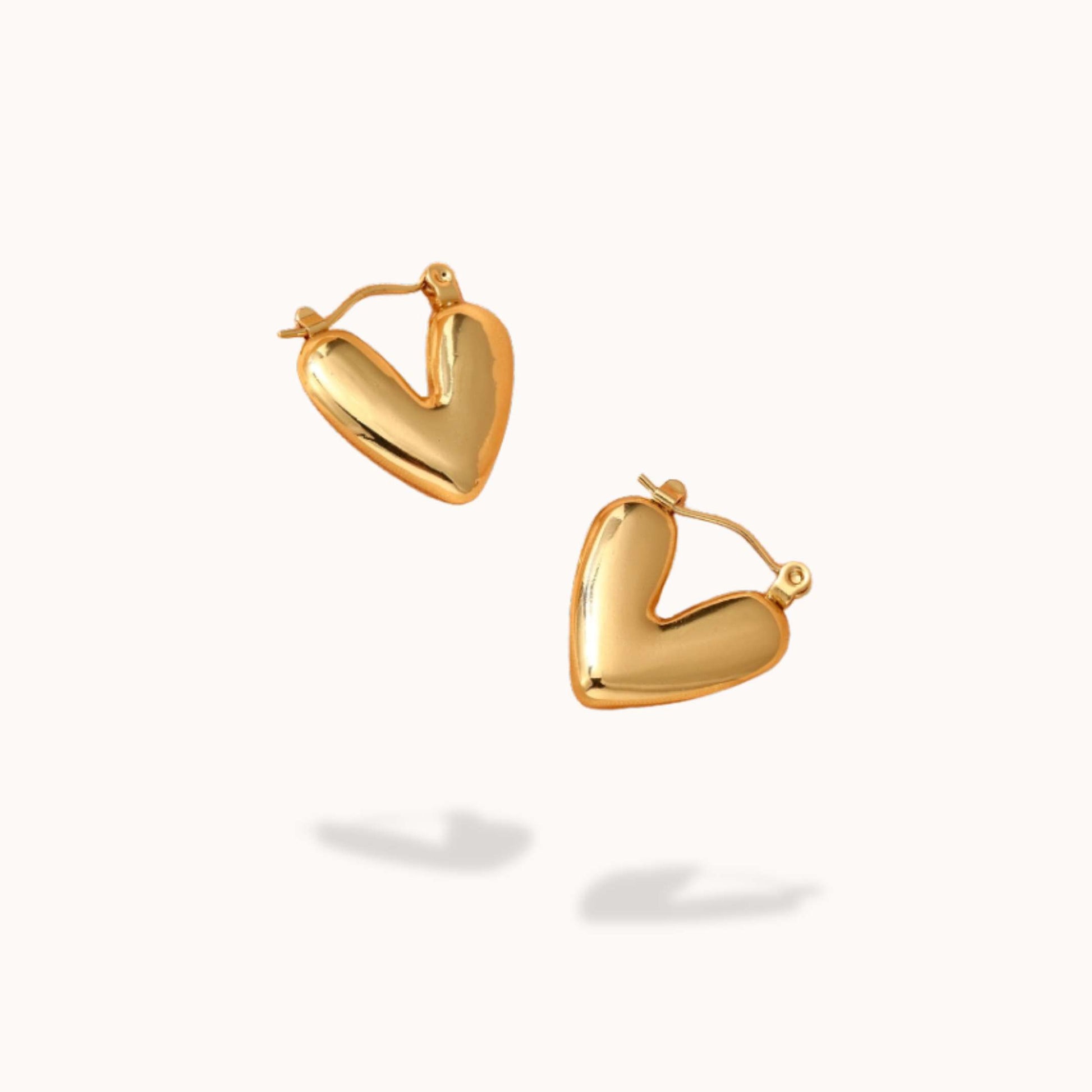 Gold heart-shaped hoop earrings on a white background