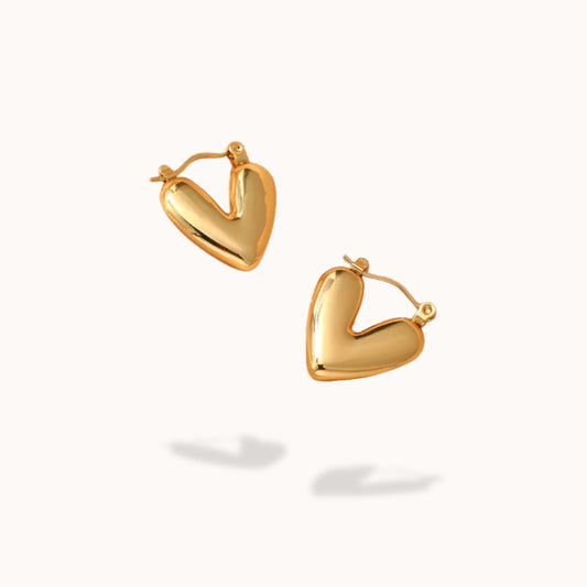 Gold heart-shaped hoop earrings on a white background
