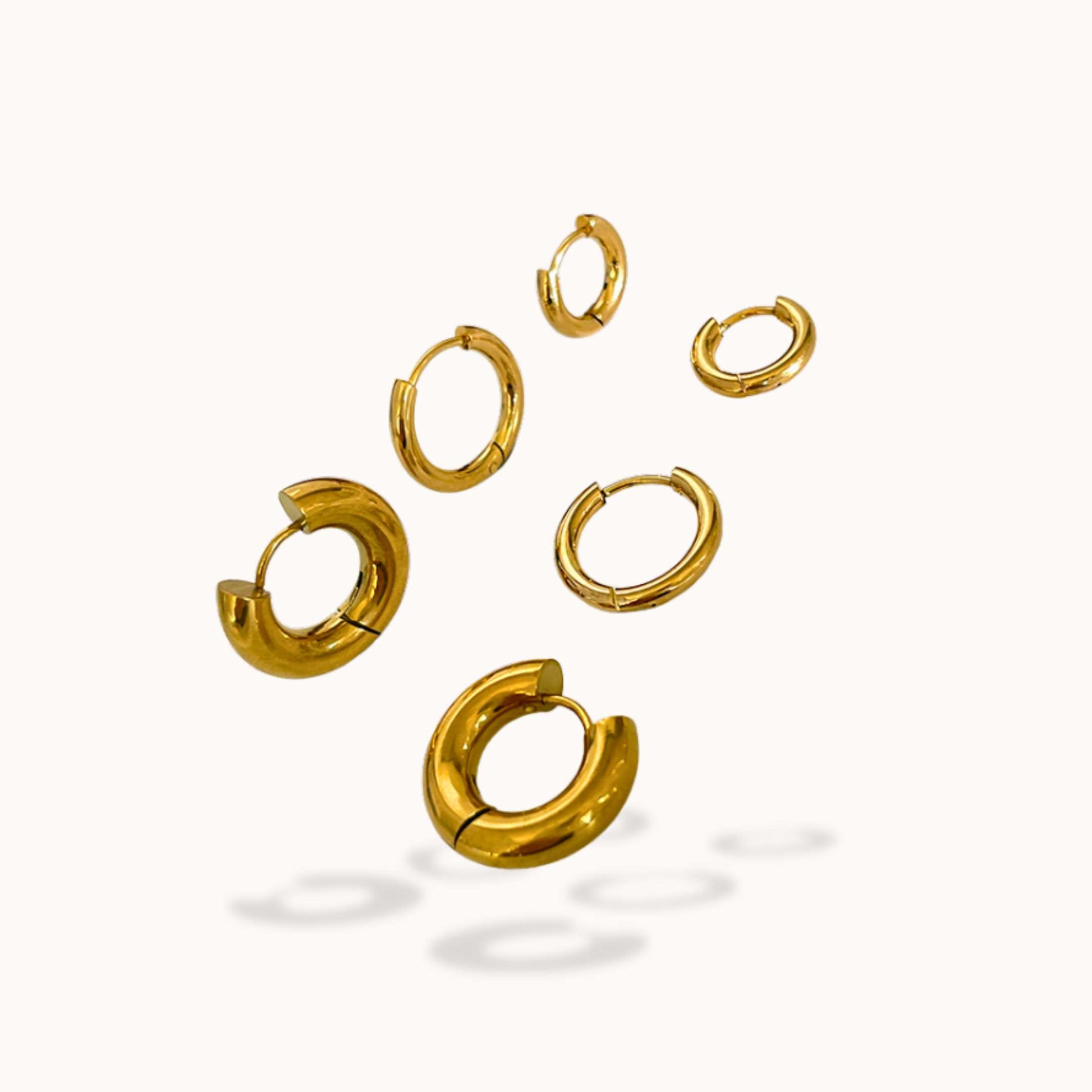 Set of gold hoop earrings on a white background