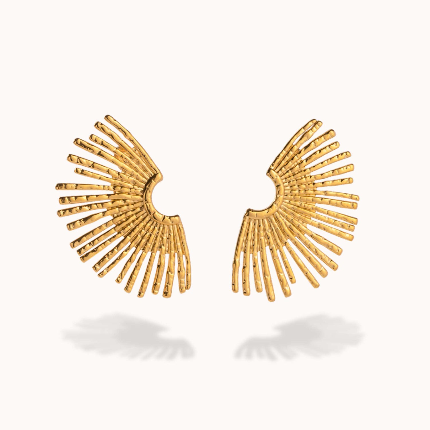 Gold fan-shaped earrings on a white background