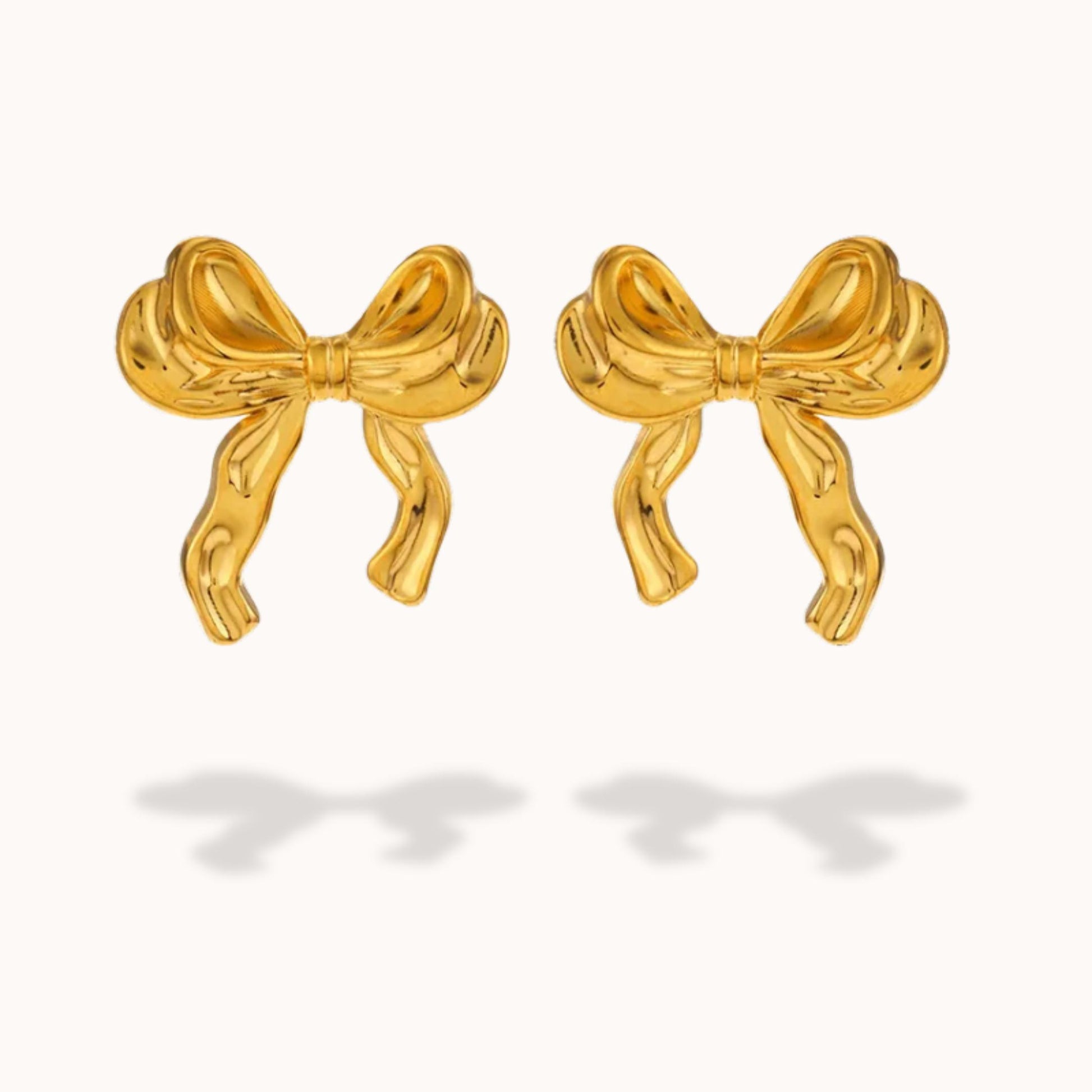Gold bow-shaped earrings on a white background