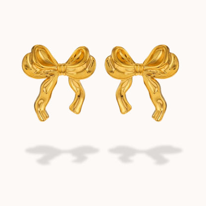 Gold bow-shaped earrings on a white background